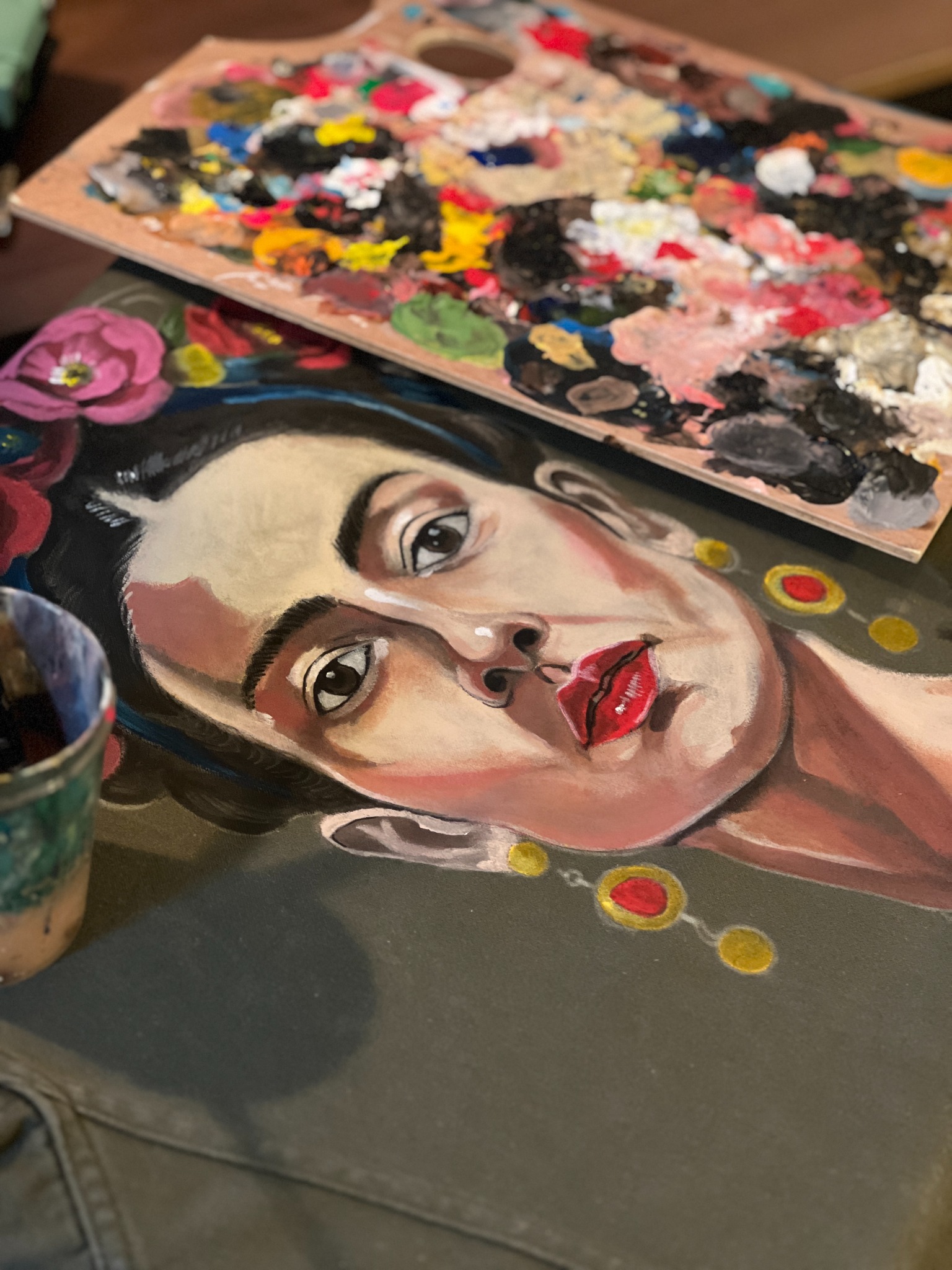 Portrait peint sur une veste, avec la palette et les pinceaux pendant la création